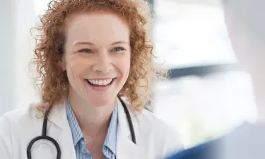 Public health nurse with DNP smiling with RN in hospital